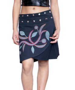 Woman wearing a stylish black wrap skirt with colorful floral embroidery and metal stud details on the waistband, paired with a black leather crop top. The skirt has an asymmetrical wrap design made from soft cotton fabric, showcasing Nepali handmade craftsmanship.